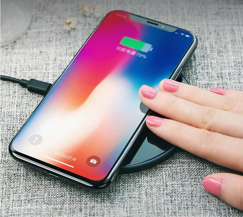 Black glass disc wireless charger with LED indicator light on smooth surface
