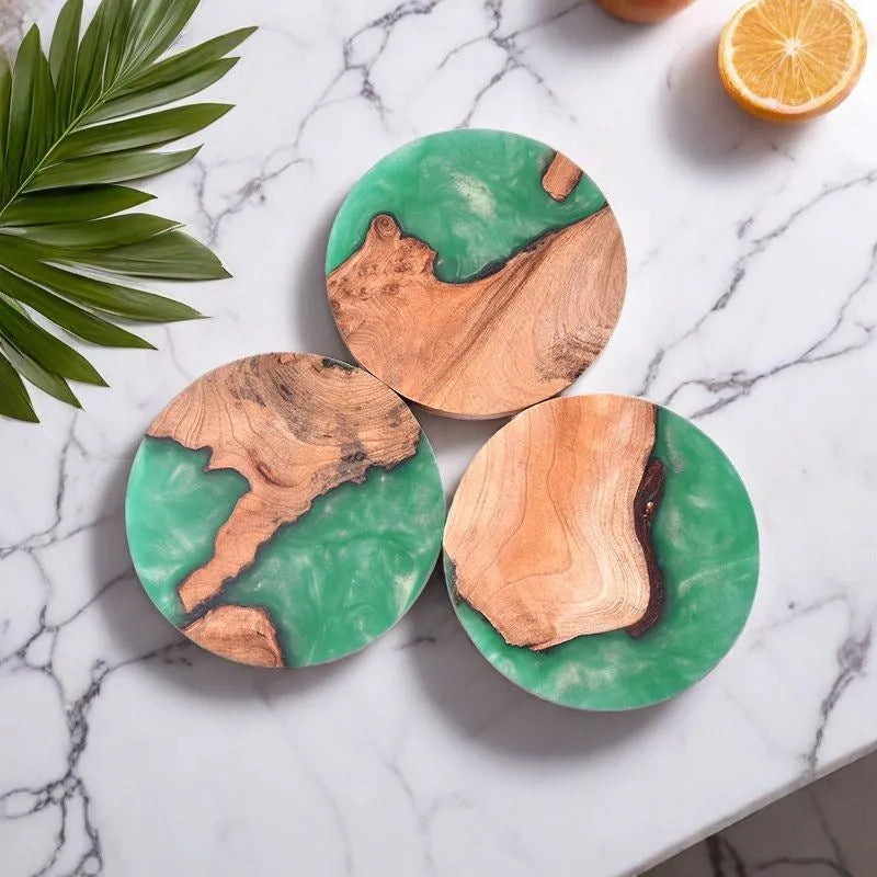 Solid colour resin coaster on a wooden table next to a mug, showing round tumour green and black options.