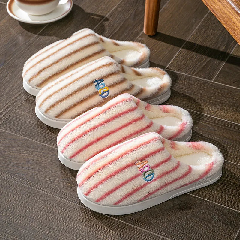 A pair of soft cotton adult slippers with a plastic sole, shown in one of five colour options.