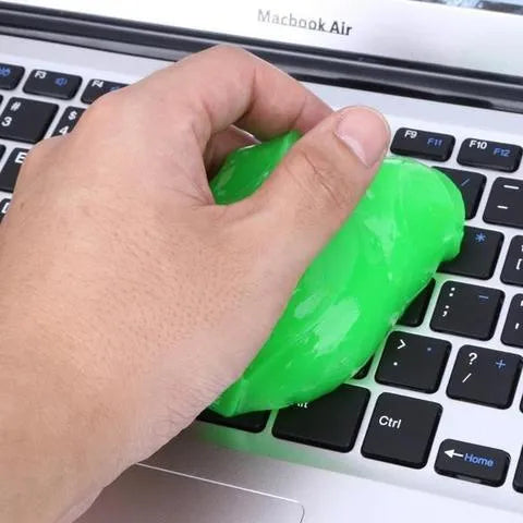 Blue and yellow lumps of Magic Cleaning Gel adhesive putty for dust removal, shown with a car vent and keyboard.