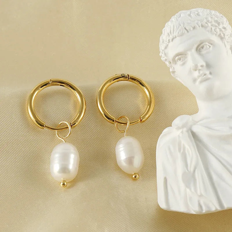 Gold geometric women's earrings with a pearl detail on a white background
