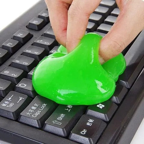 Blue and yellow lumps of Magic Cleaning Gel adhesive putty for dust removal, shown with a car vent and keyboard.