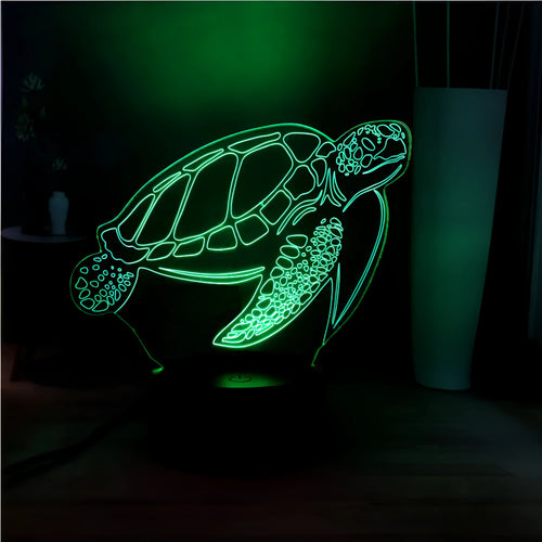 3D sculpted green turtle LED night light glowing with multi-colours on a dark surface
