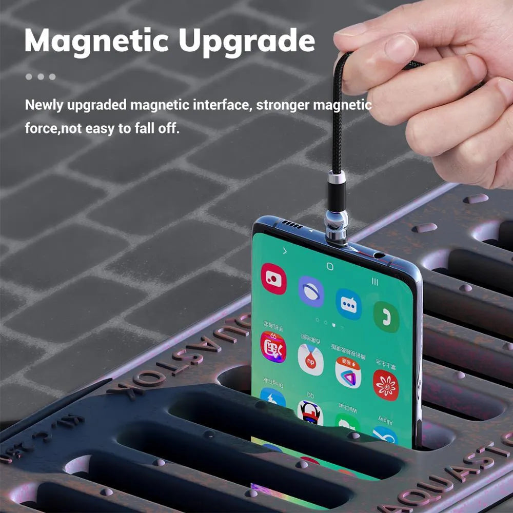 Black magnetic charging cable with spherical connectors showing 360-degree rotation on a table.