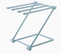 Light grey foldable plastic dishcloth shelf mounted on a wall holding towels.