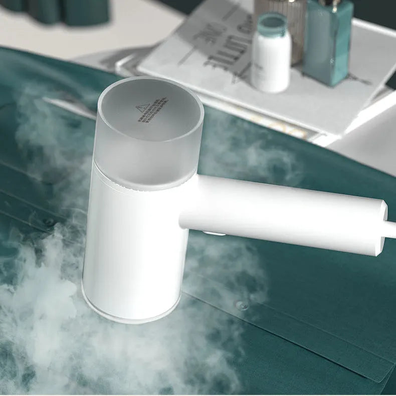 White hanging garment steamer with hand-held hook and stainless steel panel.