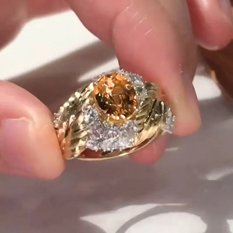 Gold-colour copper feather ring with a geometric design and a yellow zircon stone.