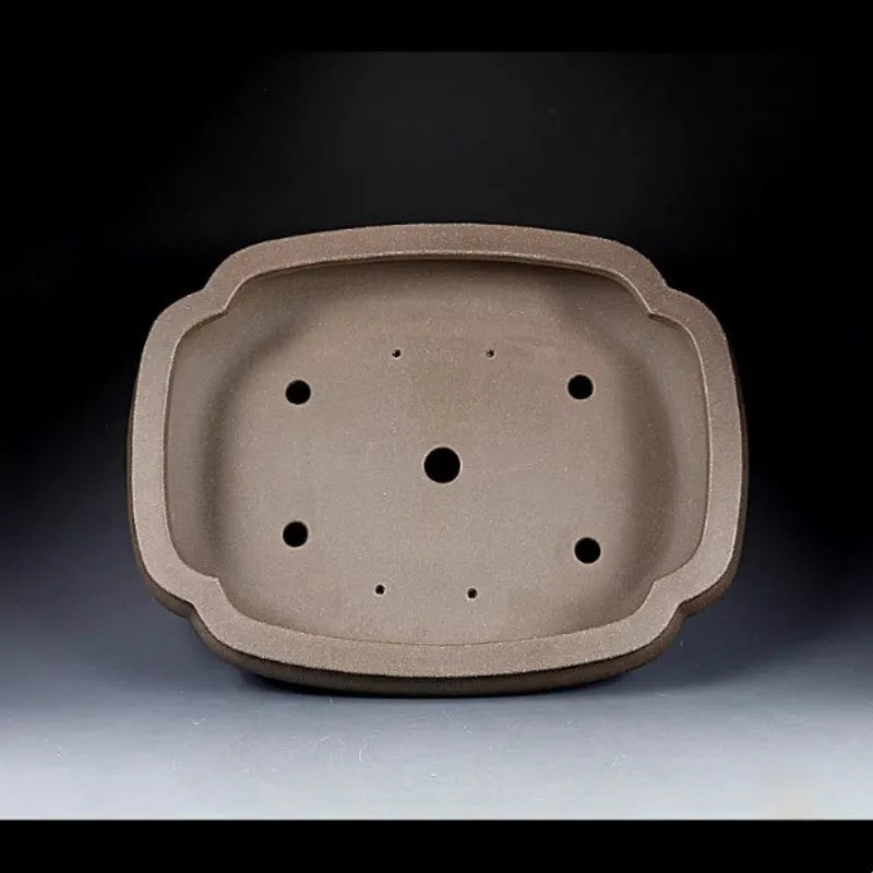 Handmade antique papaya-shaped purple clay flower pot shown from the side.