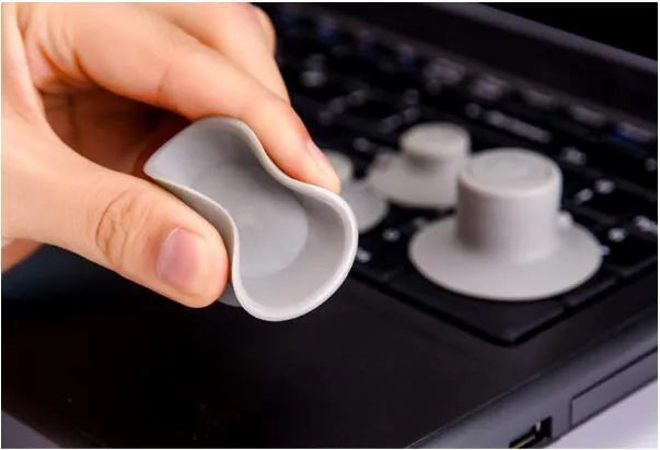 Four grey durable plastic laptop cooling pads, two large and two small, on a wooden desk