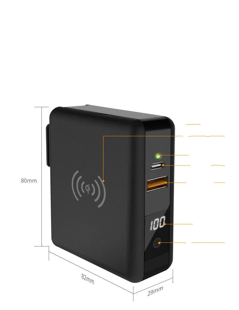 Black Super QI wireless power bank with integrated folding plug shown on a table next to a smartphone.