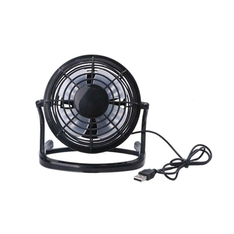 Mini adjustable tilt USB desk fan in black, shown on a desk next to a laptop
