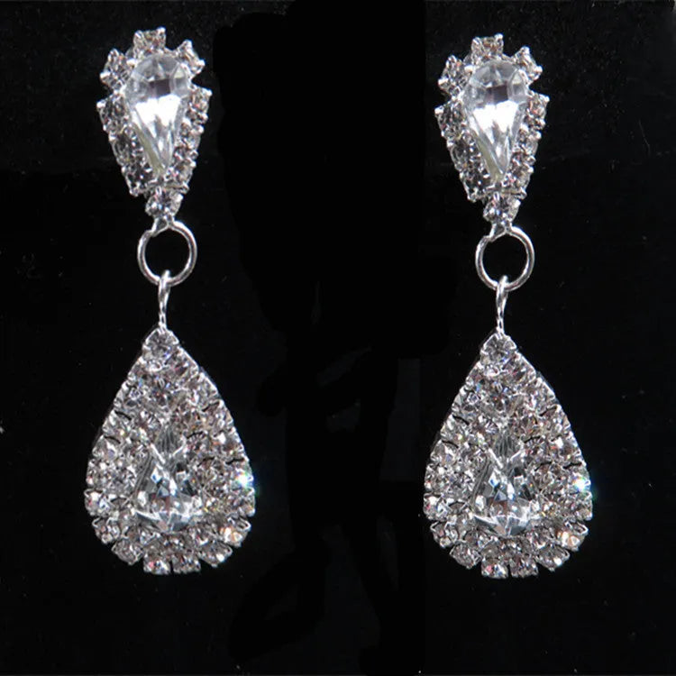 Gold bride wedding accessories set with drop earrings and necklace on white background