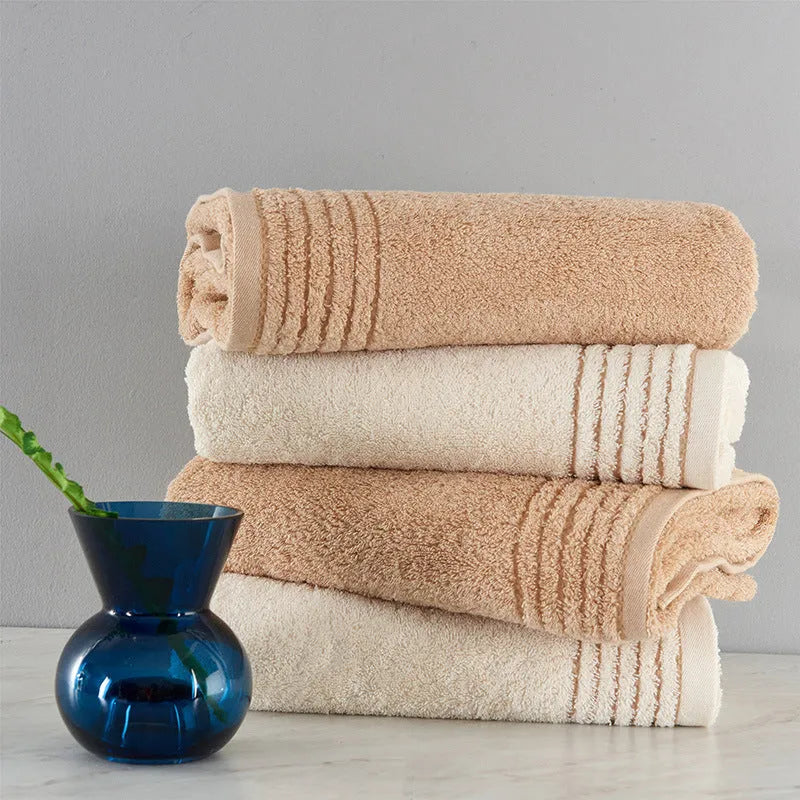 Beige and brown cotton towel set showing bath towel, hand towel, and face cloth sizes