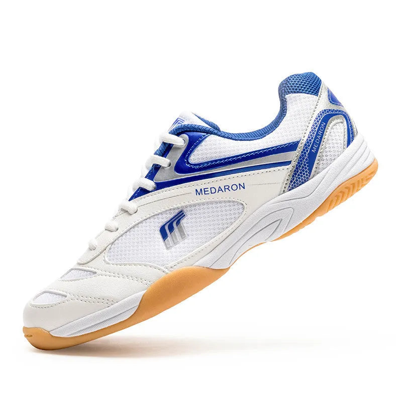 White table tennis sneakers with red trim, showing round toe and lace-up front.
