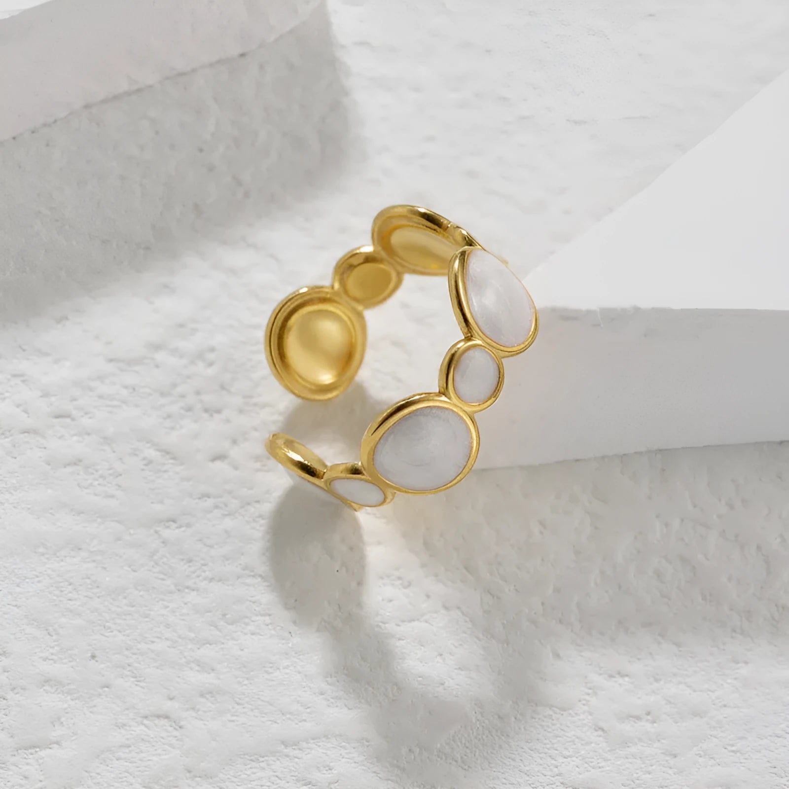 Silver geometric ring with adjustable opening on a plain background.