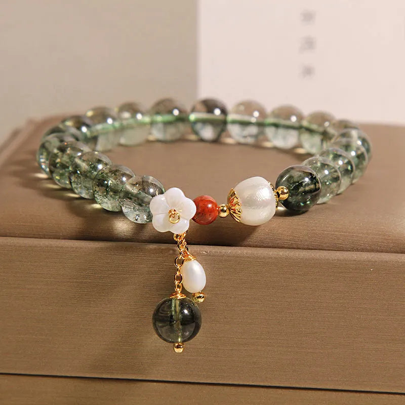 Green phantom quartz crystal bracelet for women with small shell flower and Bells of Ireland design details.