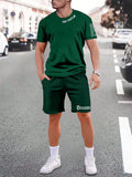 Man wearing a blue short-sleeved top and matching shorts from a sports style suit set.
