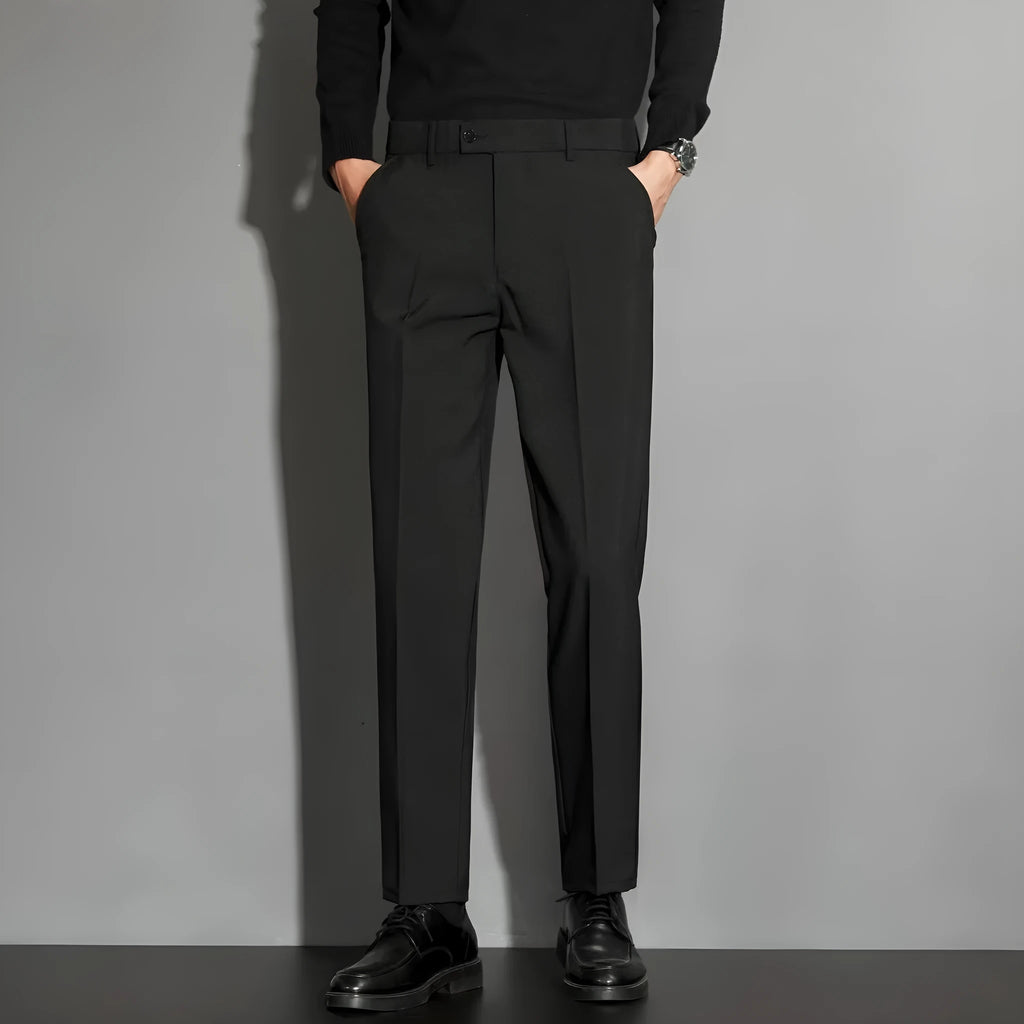 Men's straight-leg ankle-length suit trousers in a light colour showing drape and fit.