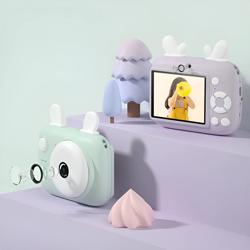 A2 Kids Macaron Mini SLR digital camera in pink, showing front and rear lenses and 2.4-inch screen.
