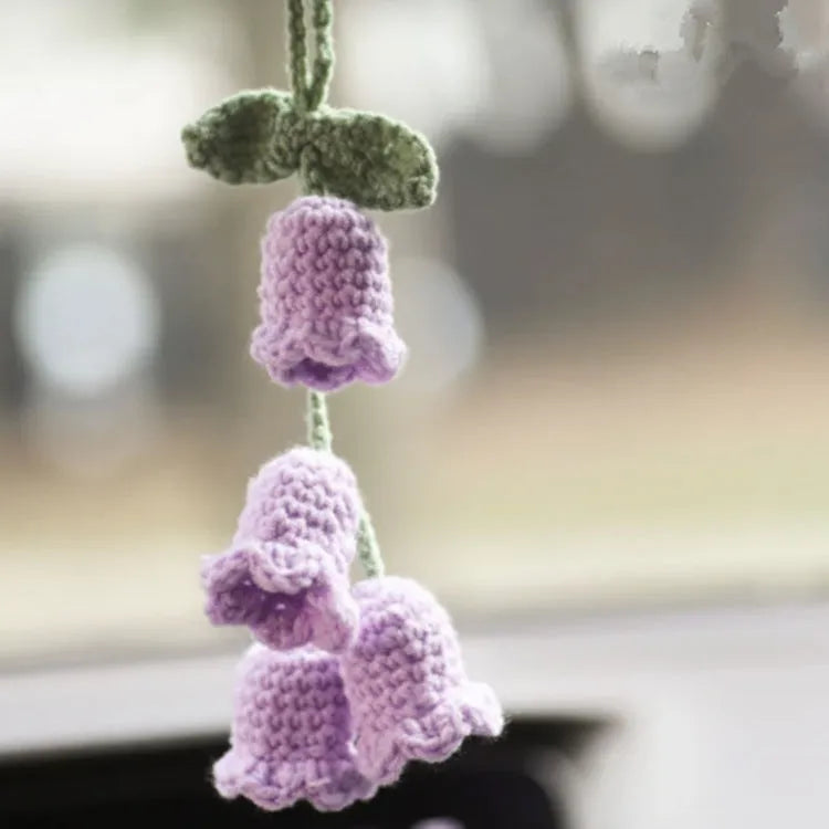 Green and white knitted wool car plant ornament hanging from a rope