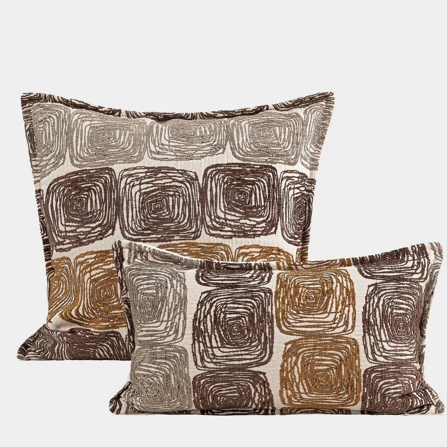 Cream and coffee abstract coil pattern square decorative pillow cover on a grey sofa.