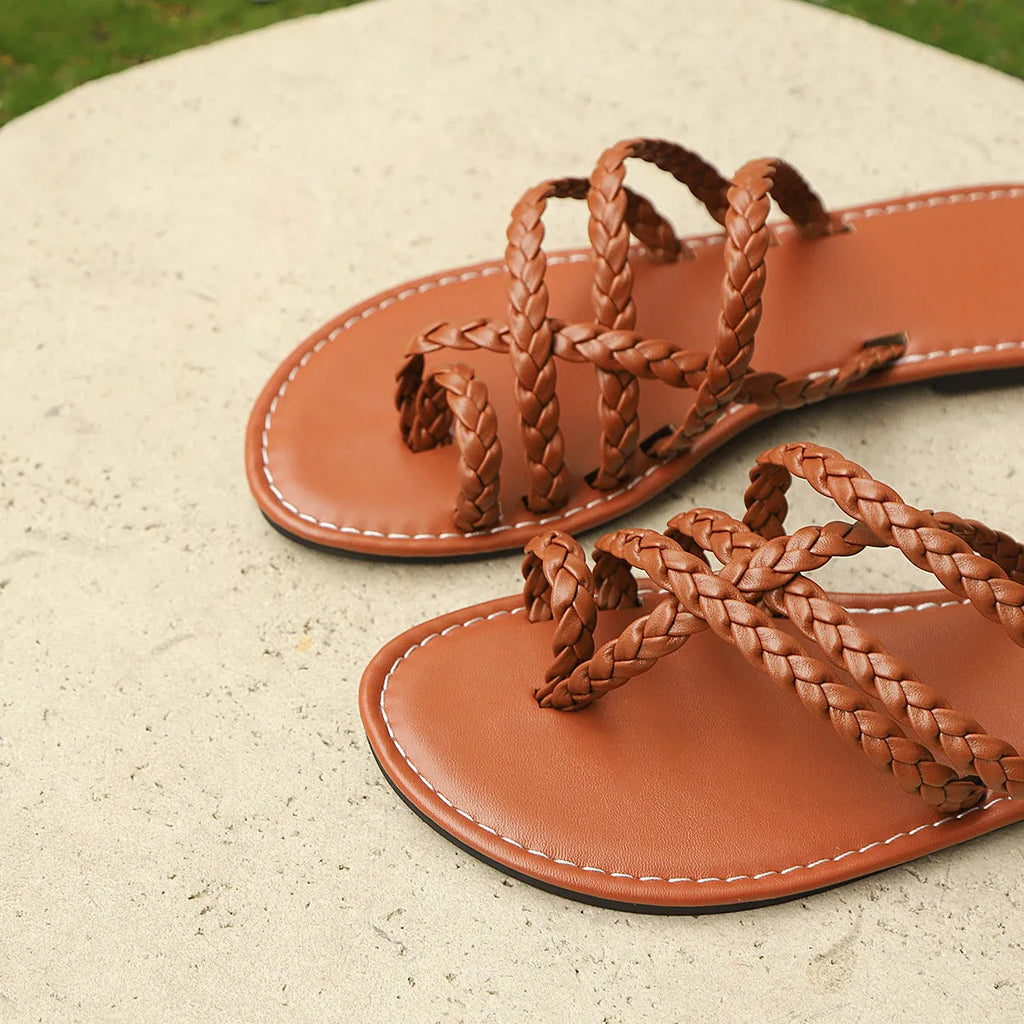 Women's white woven flat sandals with an adjustable strap over the instep and a flexible rubber sole.