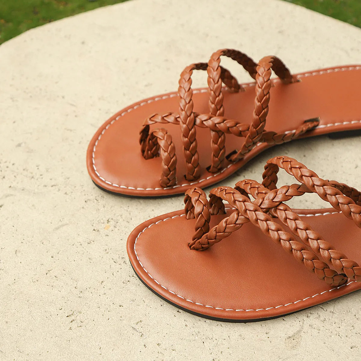 Women's white woven flat sandals with an adjustable strap over the instep and a flexible rubber sole.