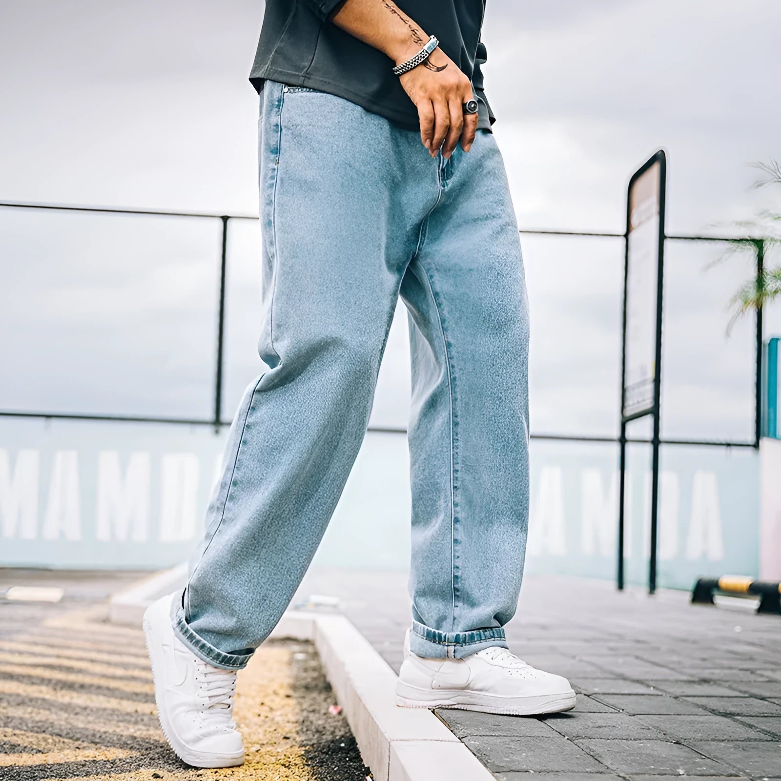 A pair of men's loose-fitting straight-leg casual jeans in dark blue cotton fabric.