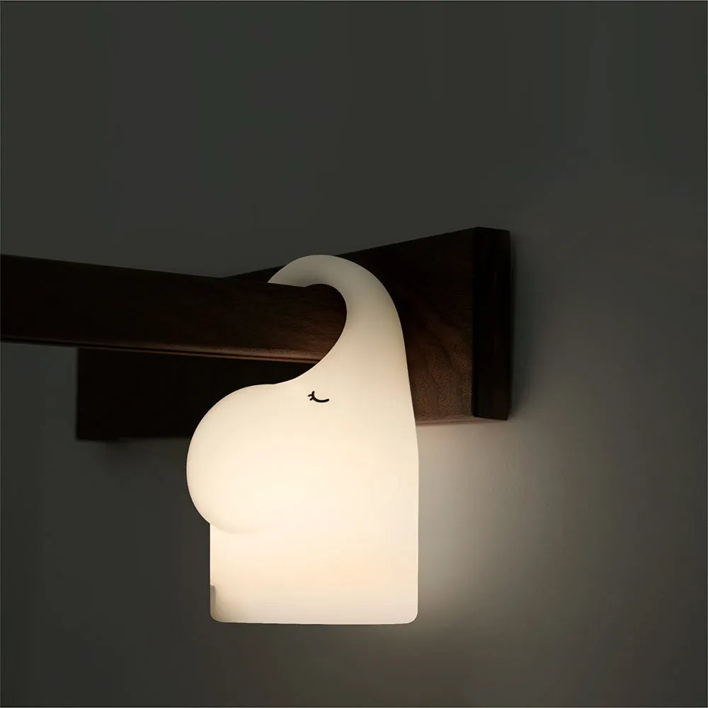 DOMI Elephant silicone night light with warm white glow on a bedside table