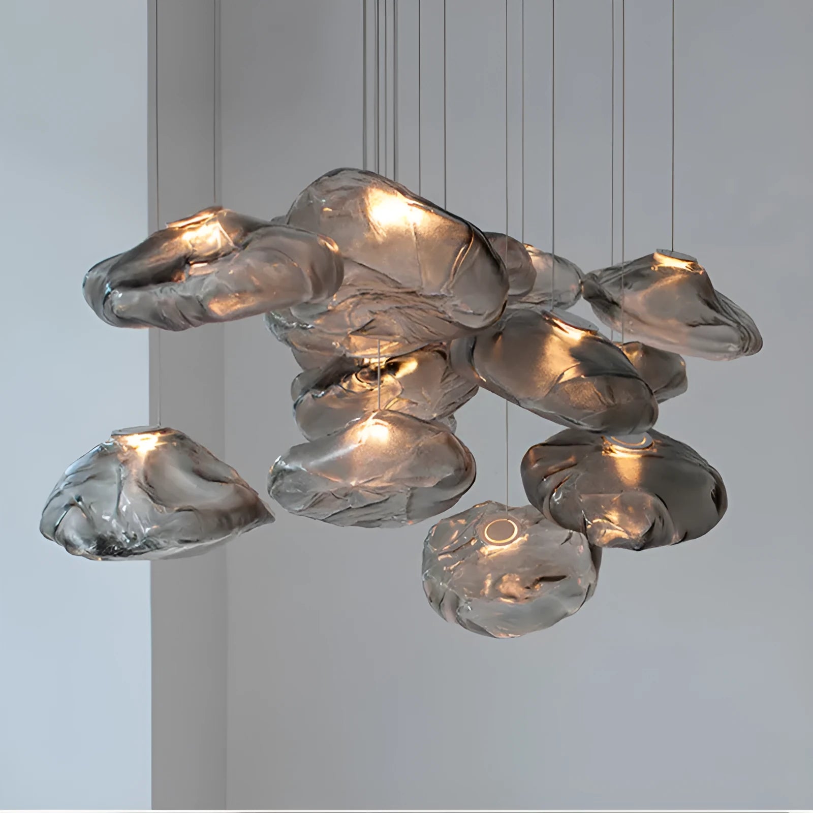 Modern light luxury glass chandelier in amber, clear, and smoke grey colours for lounge lighting.