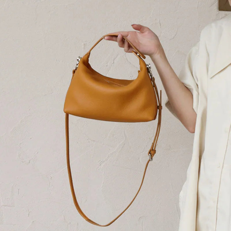 Genuine leather brown one shoulder lunch box bag with zipper closure and multiple internal pockets on white background