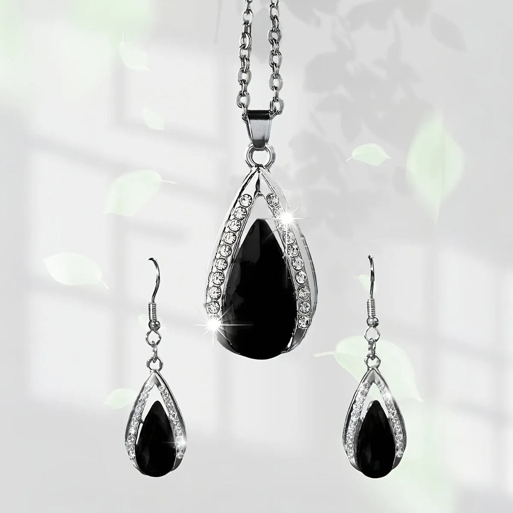 Black and red teardrop glass pendant necklace and matching earrings set on a grey background