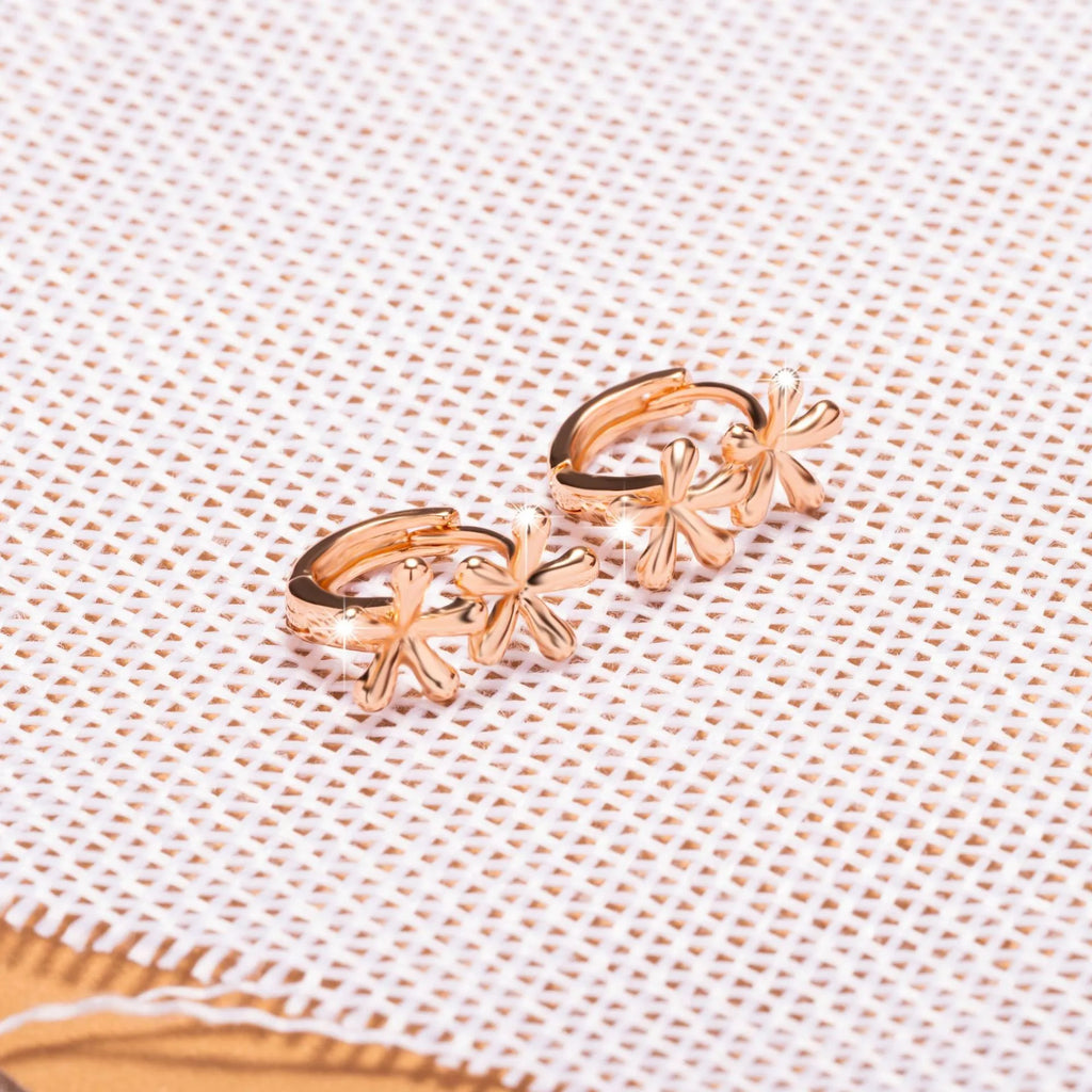 Silver rose gold electroplated circular waterdrop flower earrings with butterfly backs on a grey background.