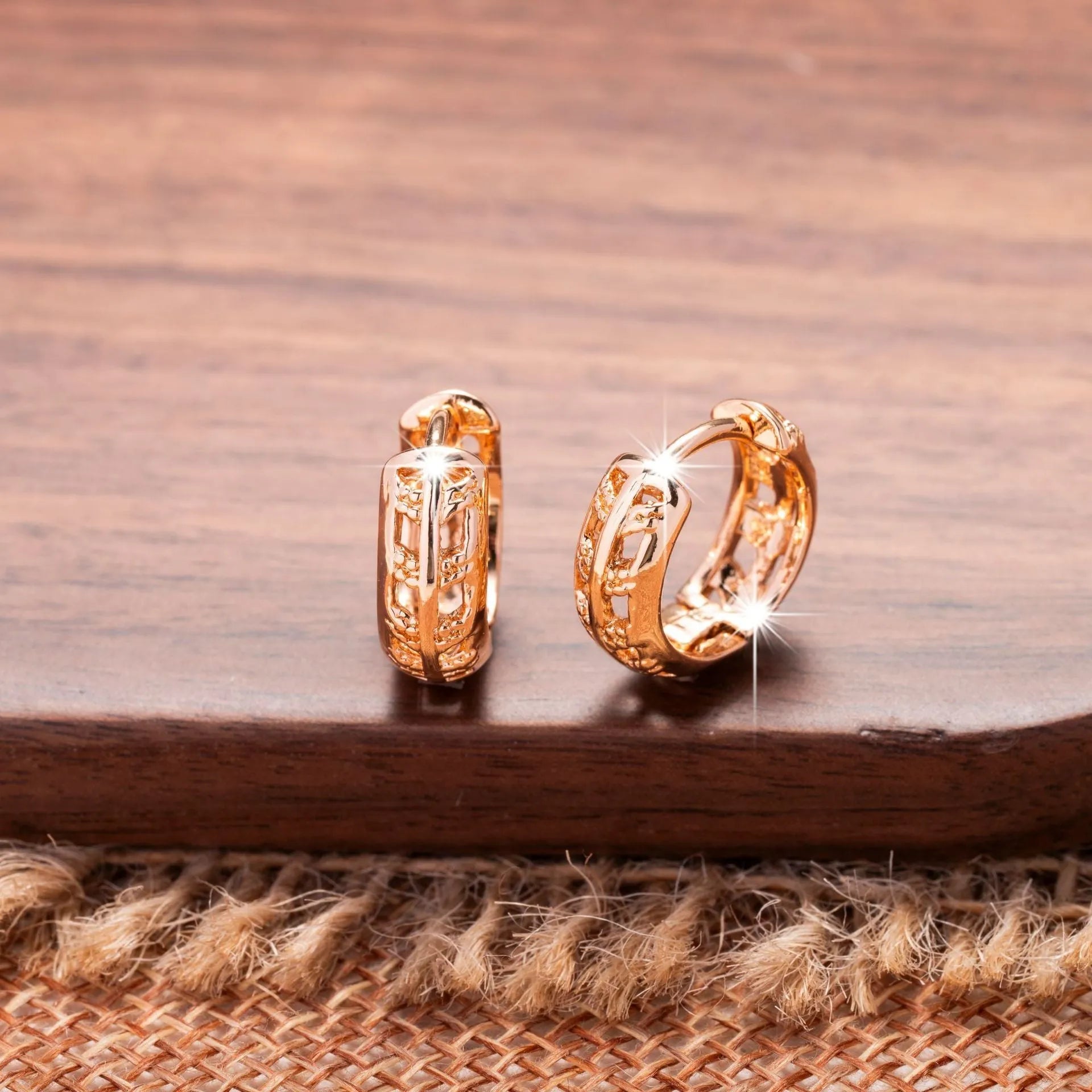 Rose gold hollowed-out heart and leaf shaped copper earrings on a white background, showing intricate cut-out details.