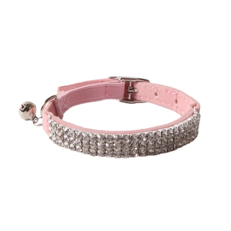 Pink flannel cat collar with elastic buckle and silver drill decoration on a grey background.