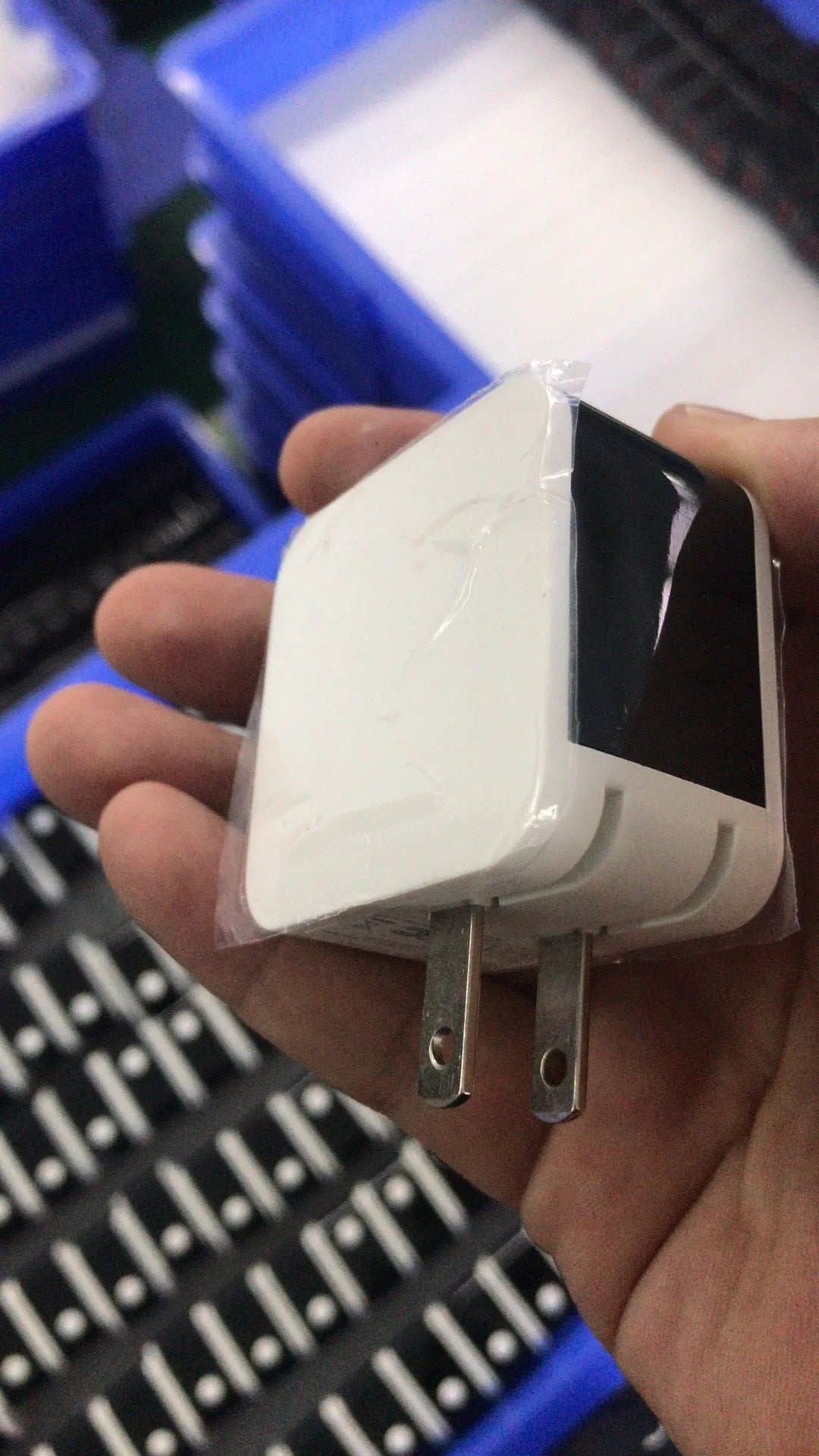 Black 5V2A dual USB wall charger with digital display screen, showing charging percentage, next to a UK 3-pin plug.