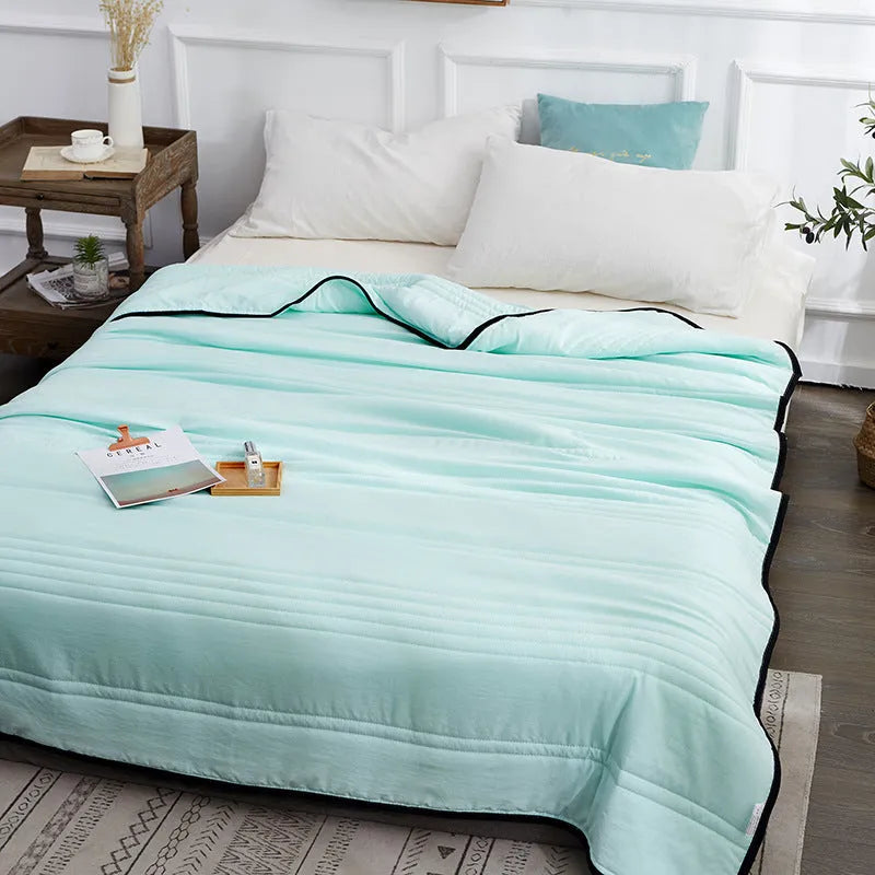 Lightweight seersucker summer quilt in various colours on a bed