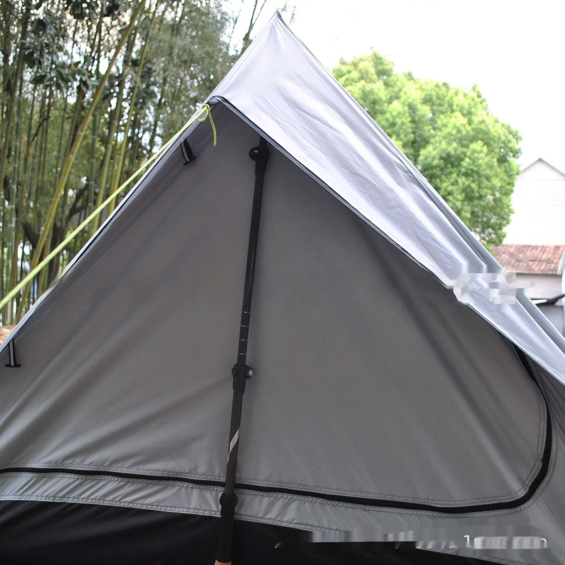 Brown A-Line pole-free cabin tent set up in a forest, showing its spacious interior for 2-3 people.