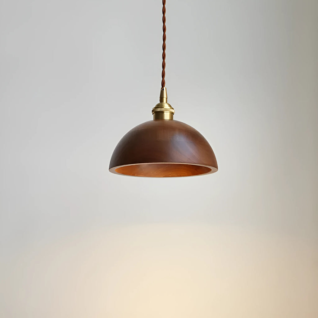 Black walnut and copper single-head droplight chandelier suspended from a ceiling.