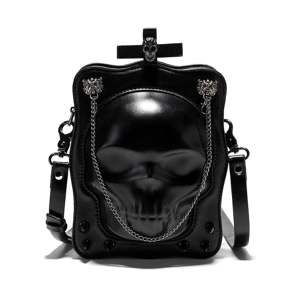 Black mini square crossbody bag with embossed skull design, metal rivets, chain strap, and top zipper.