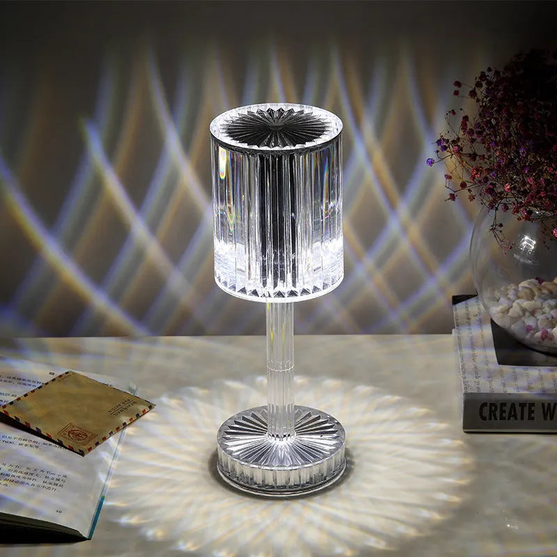Modern crystal table lamp with transparent bead shade and metal stand on wooden surface