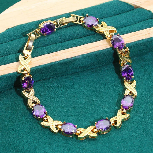 An 18k gold plated jewellery set with blue cubic zirconia stones, showing necklace, earrings, ring, and bracelet.