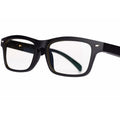 Black smart glasses with Bluetooth speakers and tinted UV-protection lenses on a table.