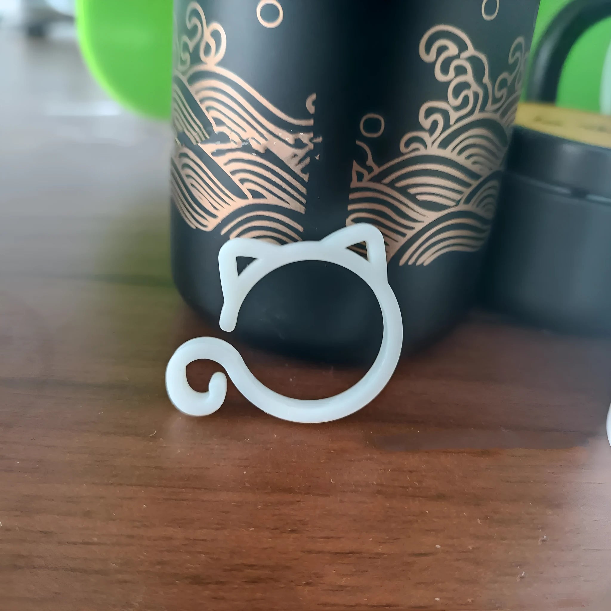 Small red cat-shaped plastic clip for plants on a white background.