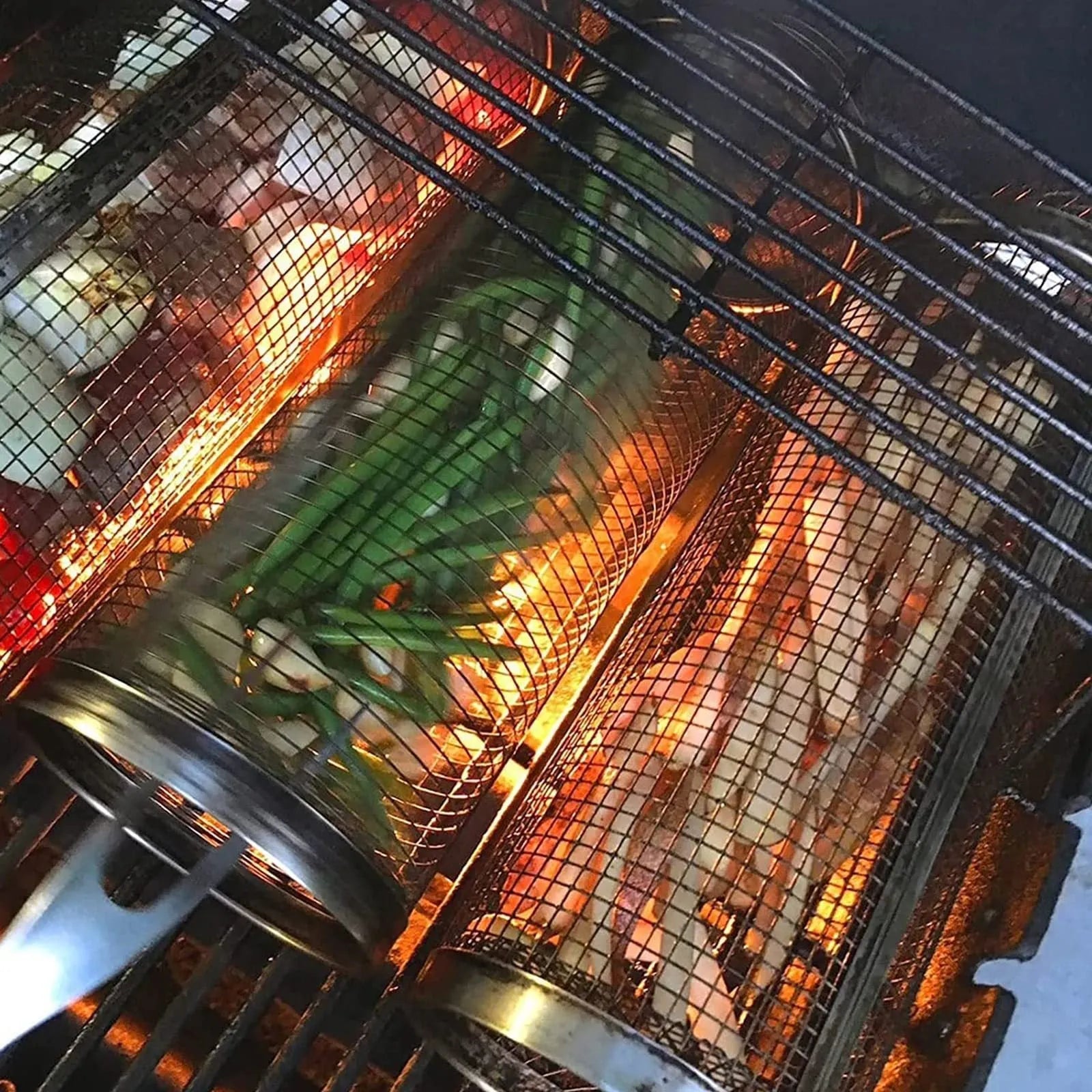 Stainless steel cylindrical rolling barbecue grilling basket with wire mesh on a grill.