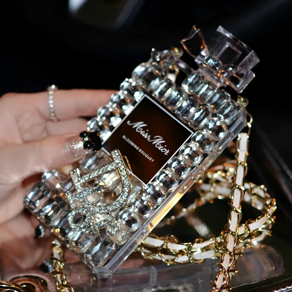 Perfume bottle bow design iPhone case with textured TPU silicone and a fixed metal chain, shown in black, gold, pink, and transparent.