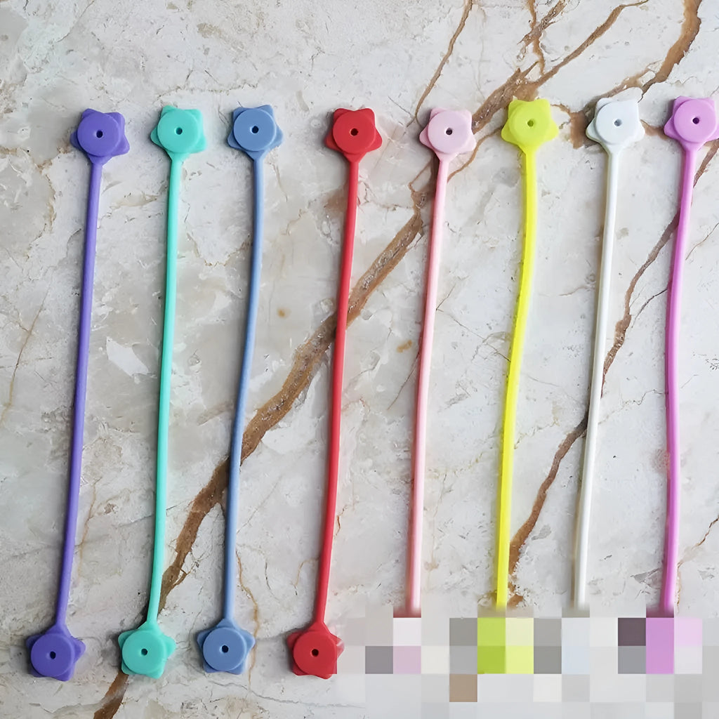 Silicone cable winder organiser with magnet in assorted colours on a table.