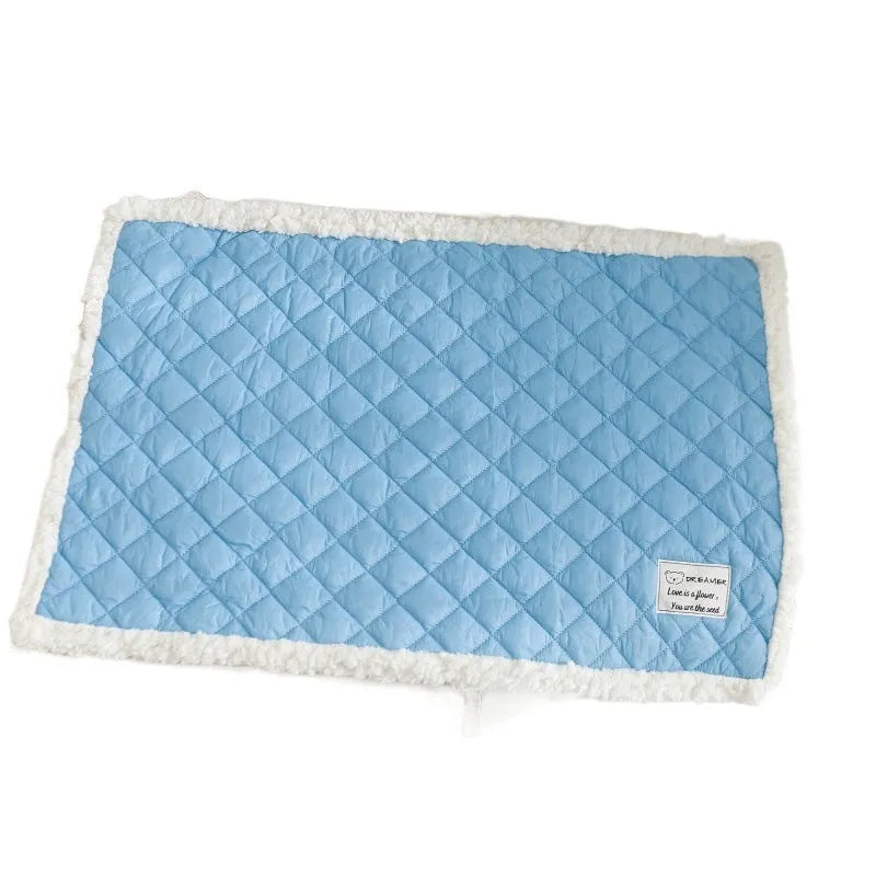 Quilted blue cloth pet blanket for cats, shown on a pet bed.