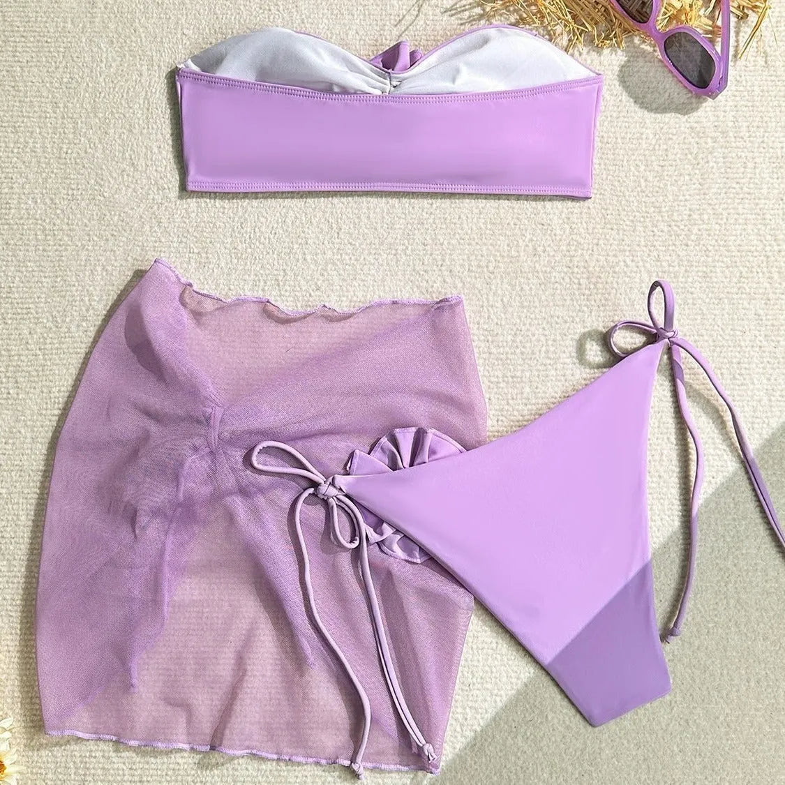Women's pink swimsuit set with 3D floral knot on tube top, high-waisted briefs, and a detachable skirt laid flat.