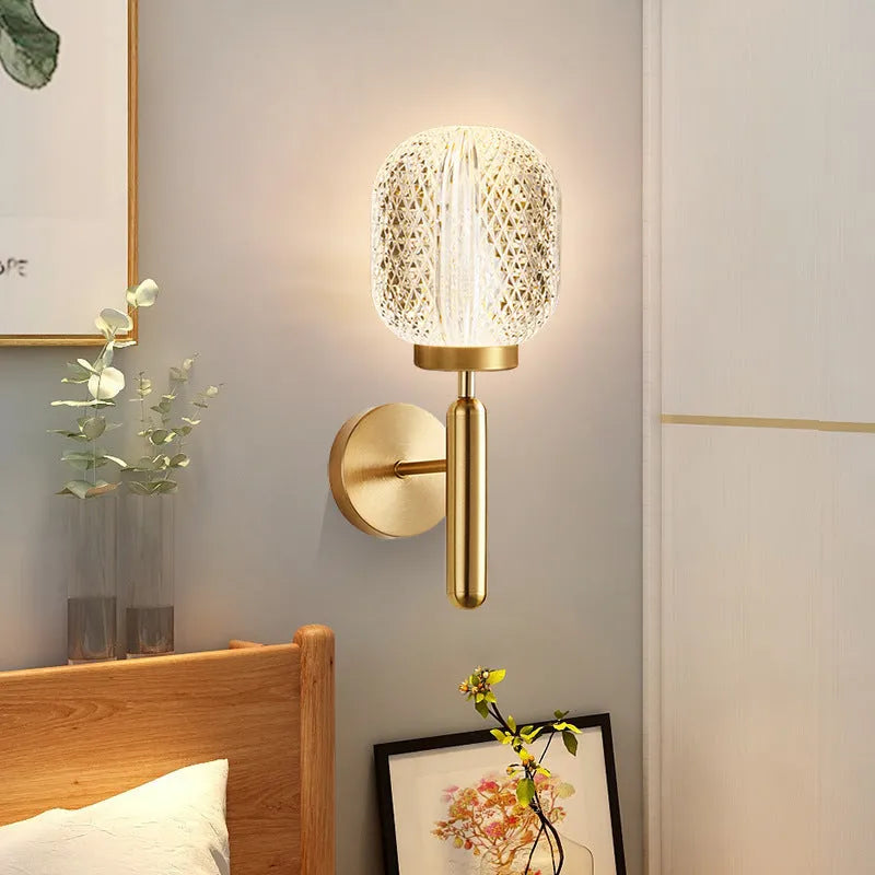 Modern double head wall lamp with a copper finish mounted on a light grey wall.